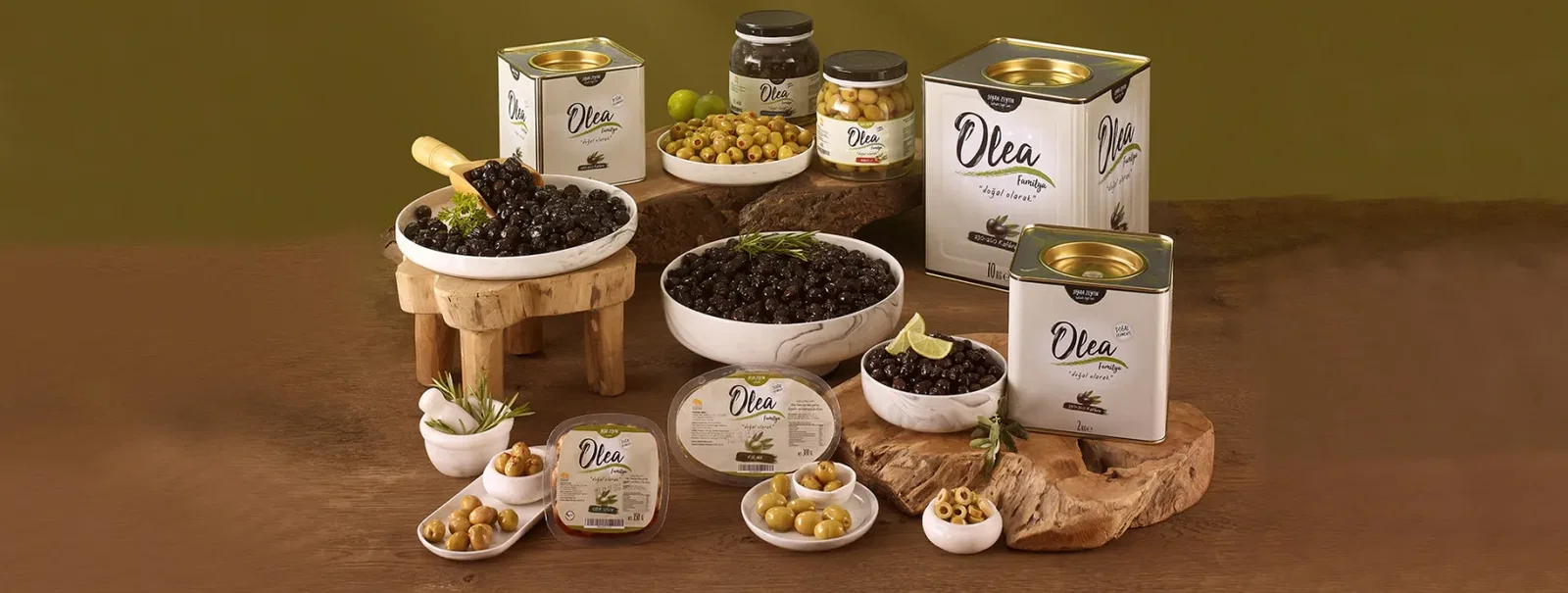 Olea olive products presented in bowls and jars on a dark table