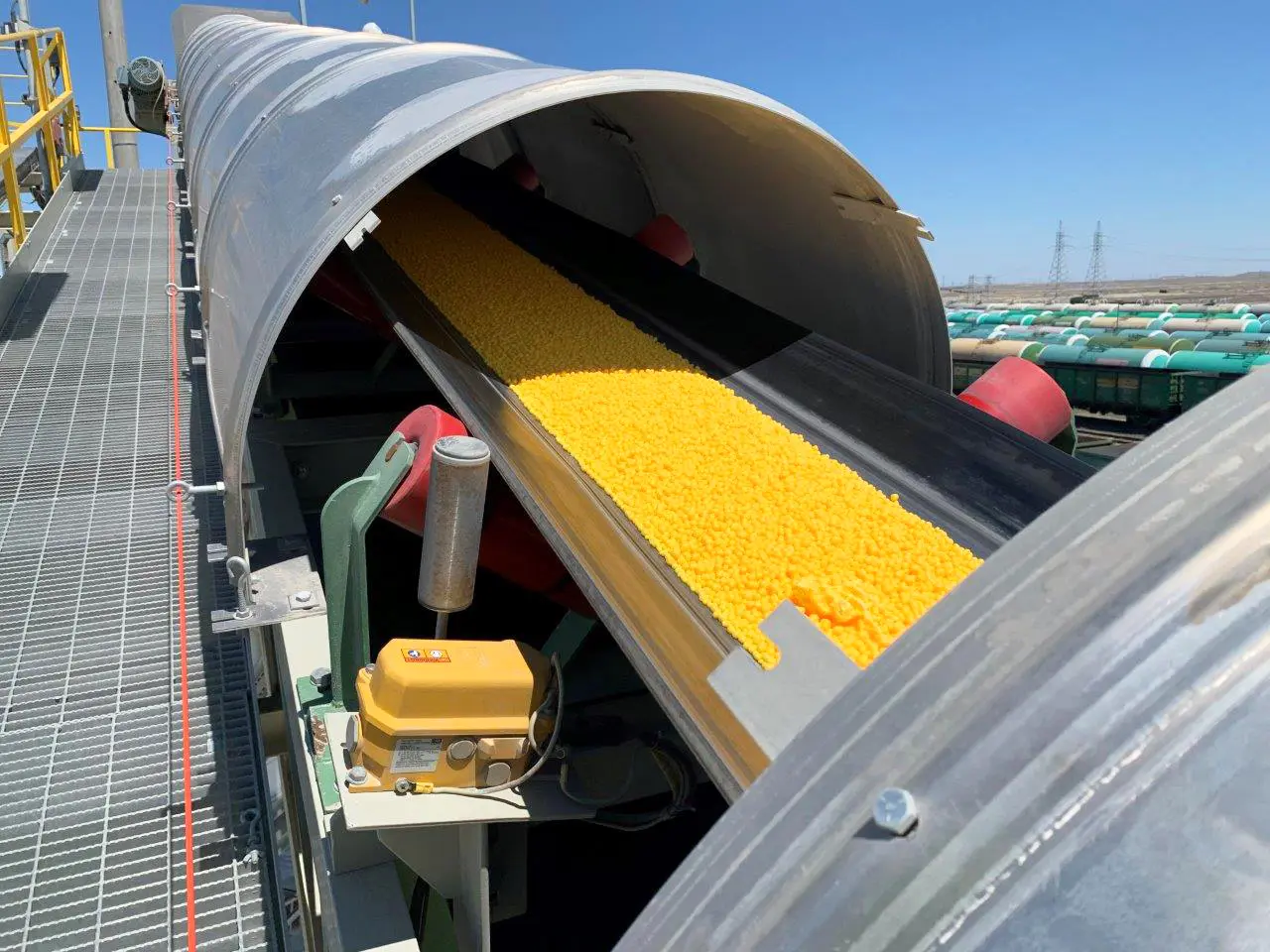 Hooded belt carrying finished granules to the rail loading station