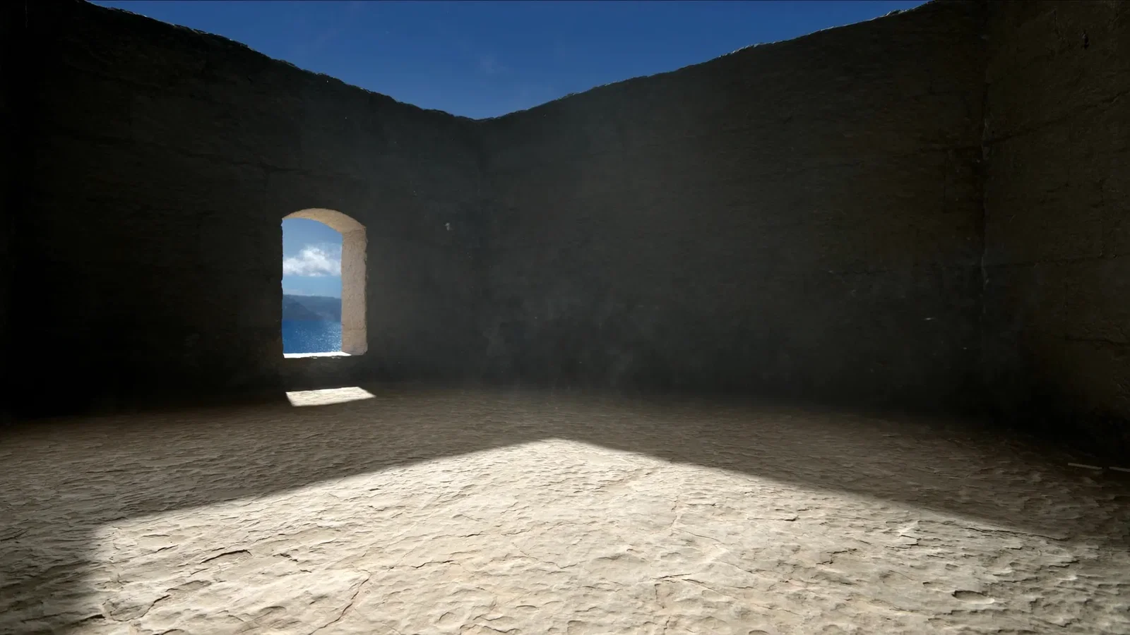 A bare stone chamber inside a coastal fortress with a single arched window looking out over a blue Aegean bay