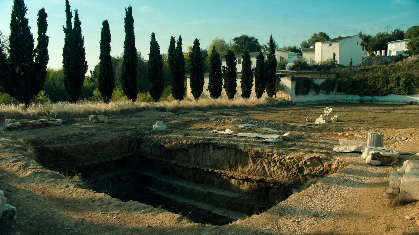 The excavated foundations and stepped tomb chamber of the Mausoleum of Halicarnassus in central Bodrum, with column drums laid out on gravel